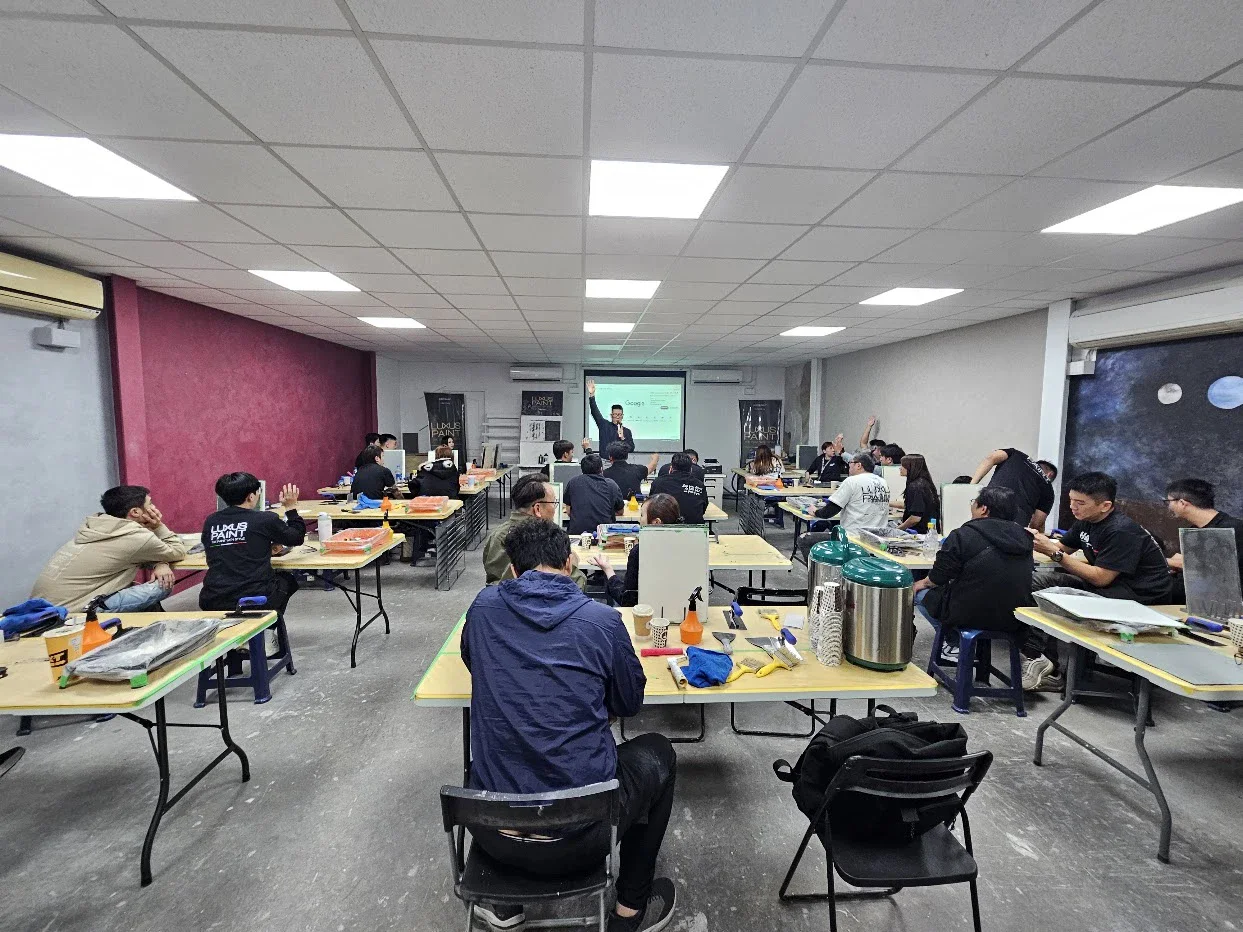 LUXUS 路克瑟士藝術塗料經銷商大會現場，二十多家經銷商坐在教室裡，看講者示範 AI 選材系統